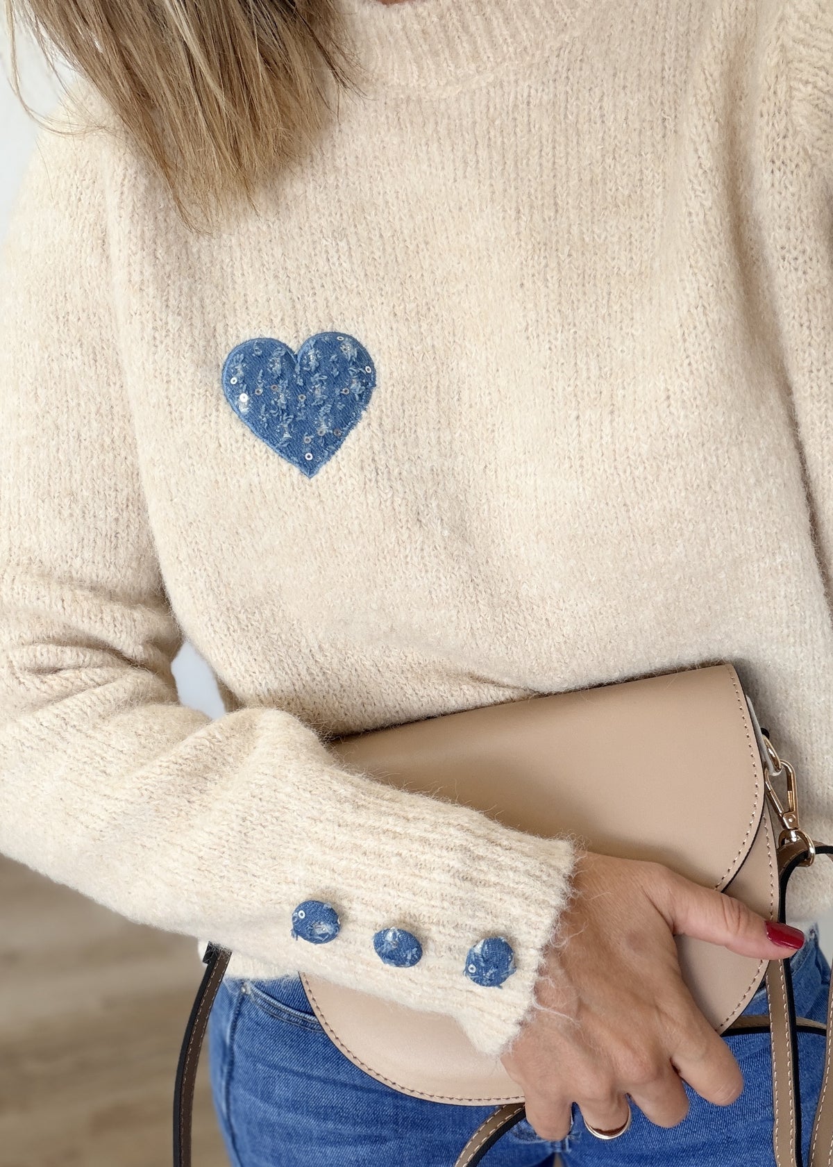 Pull écru à cœur bleu et boutons aux poignets